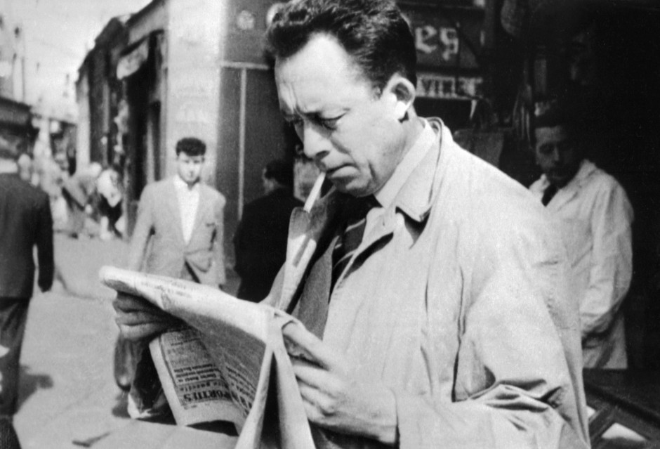 Foto de Albert Camus leyendo el periódico